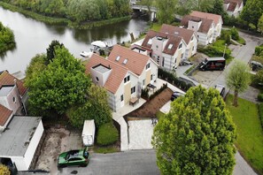 A residential area with houses, a river, and a bridge. - Holiday home in a holiday park in Friesland (Makkum)