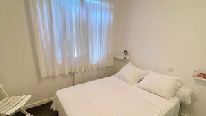 A neatly made bed with white linens in a room with a window covered by sheer curtains. - Perfect vacation house in the 44ha of Cap Ferret (Lège-Cap-Ferret)
