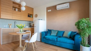 A modern living space with a kitchen, dining area, and a blue sofa. - NEW, REFINED, ELEGANT AND EXCLUSIVE APARTMENT LOCATED IN THE CENTER OF THE CITY. (Agrigento)