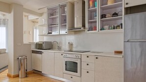A modern kitchen with a dishwasher, oven, and stainless steel appliances. - VESTA - Heliopolis Residence (Ash-Shruq)