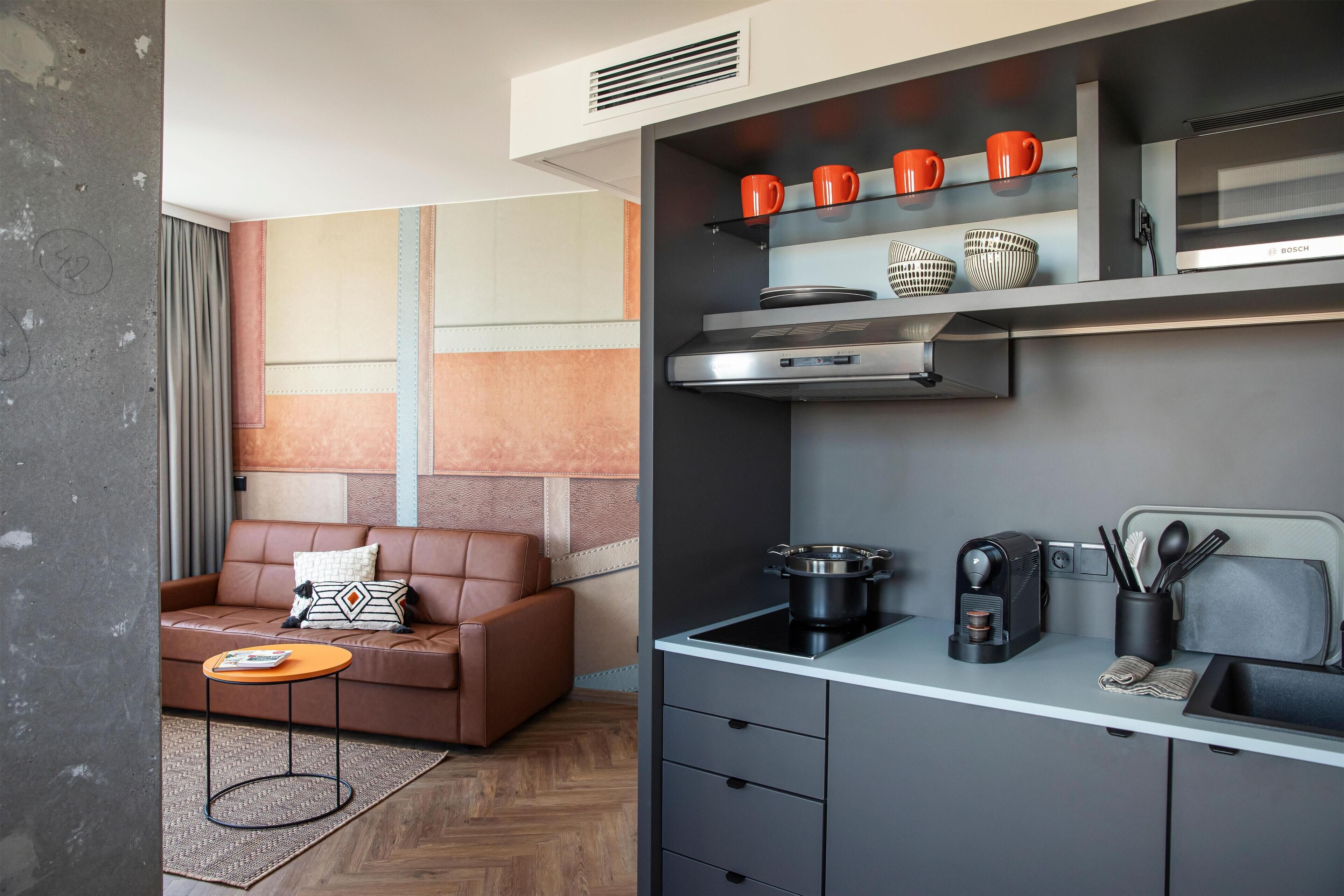 Una cocina compacta con horno Bosch, una cafetera y un lavabo.