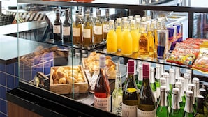 A bakery display with pastries and drinks, and two orange figurines on a shelf.