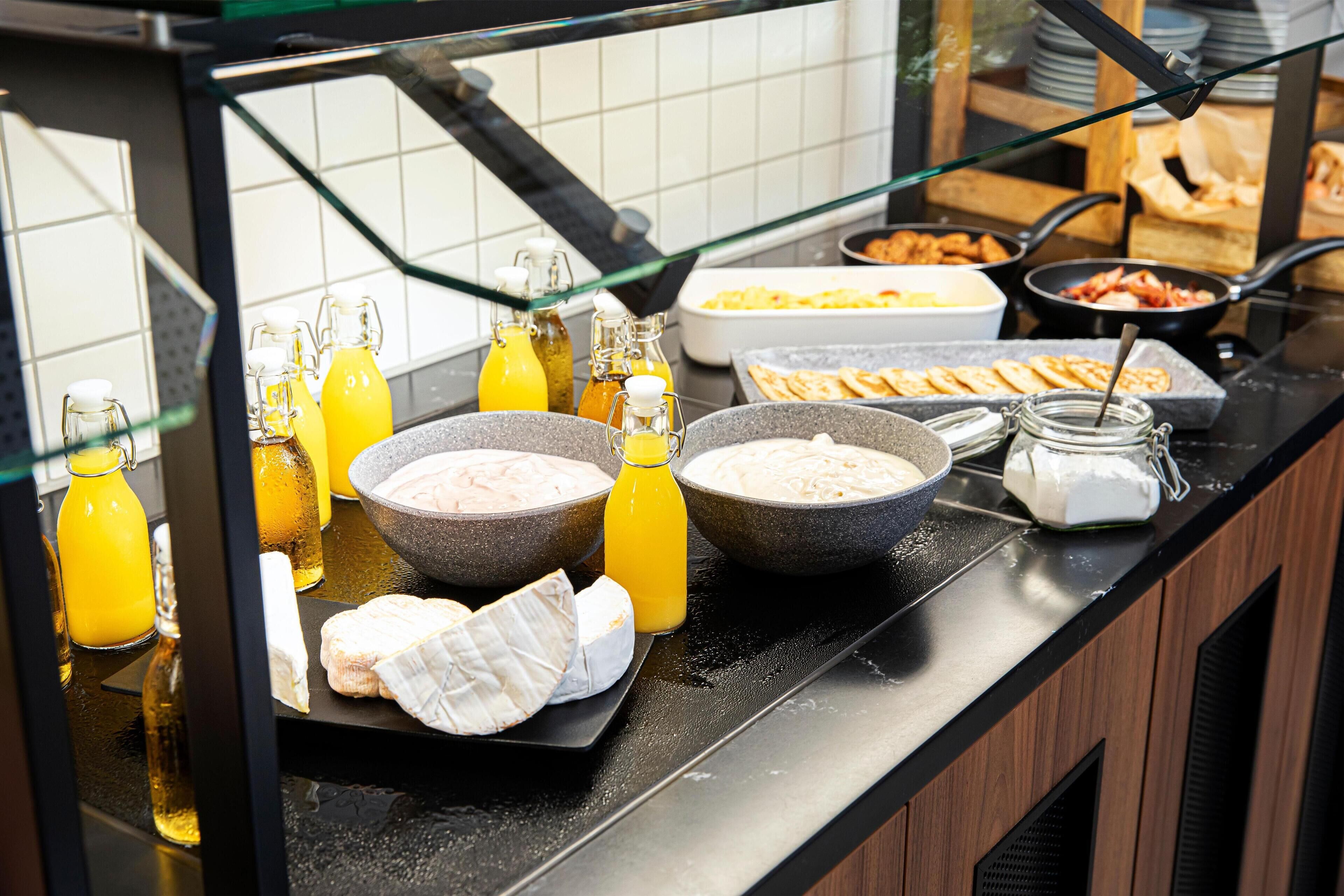 A buffet counter with various food items and condiments.