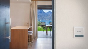 Una habitación de hotel con vistas a montañas y un lago.