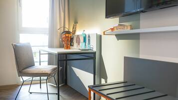A modern room with a desk, chair, and a TV mounted on the wall.