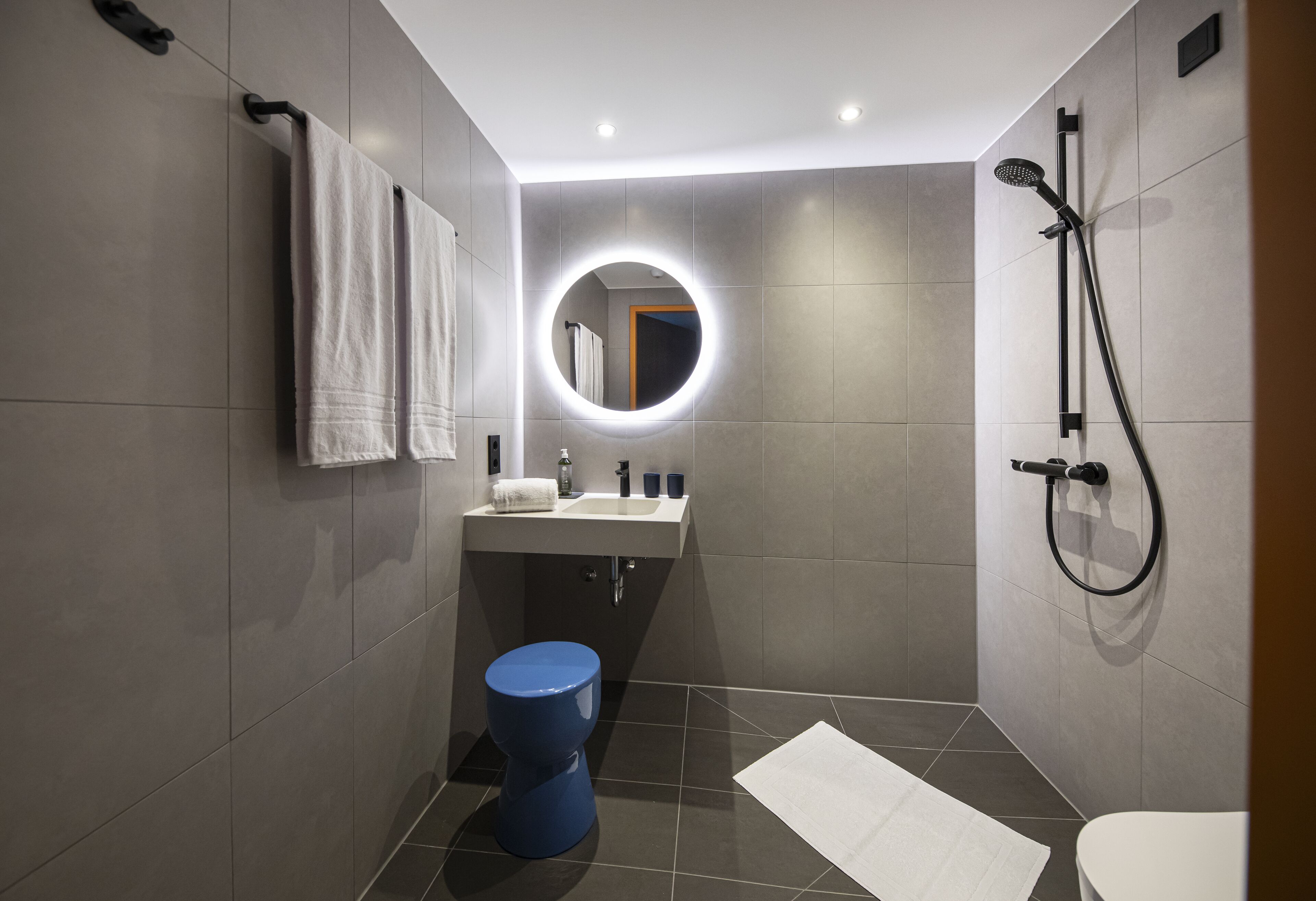 A modern bathroom with a toilet, sink, and shower.