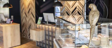 A bakery display case with pastries and a decorative bird.
