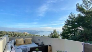 Une terrasse sur le toit avec un canapé, une petite table et un jacuzzi.