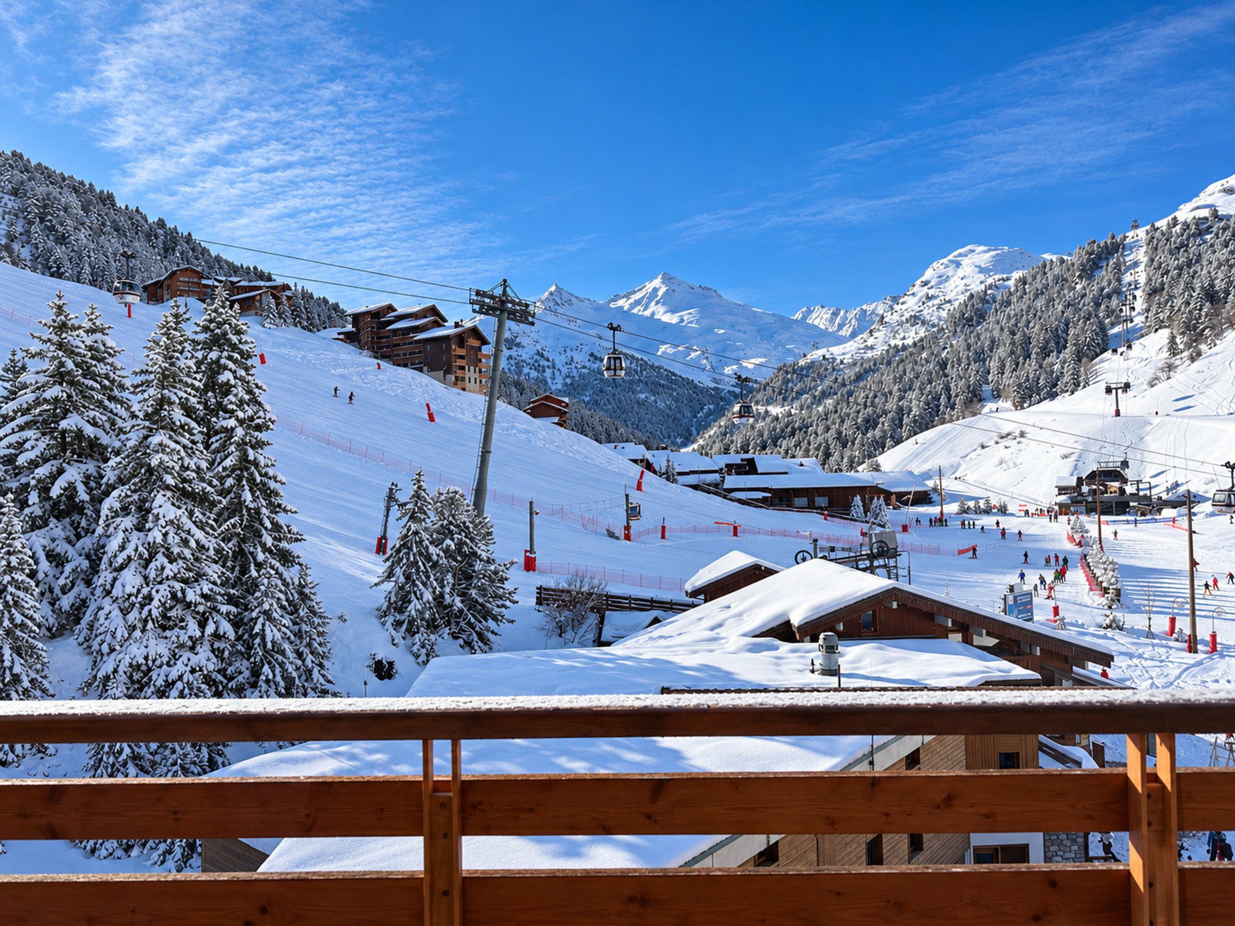 Une station de montagne enneigée, avec des remontées mécaniques, des chalets en bois et un ciel bleu azur.