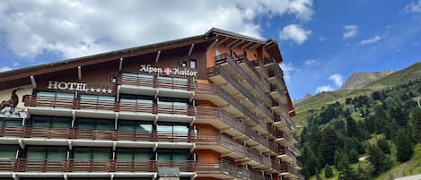 A hotel with multiple balconies, a restaurant, and a grill.