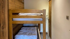 A bunk bed in a room with wooden walls and a sloped ceiling. - T2 + Sleeping Area 6 Pers, South, Wifi, La Clusaz (La Clusaz)
