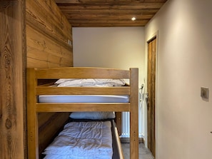 A bunk bed in a room with wooden walls and a sloped ceiling. - T2 + Sleeping Area 6 Pers, South, Wifi, La Clusaz (La Clusaz)