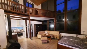A spacious living area with a high ceiling, a balcony, a sofa, a coffee table, and a bed. - Außergewöhnlich Wohnen in Weimar (Weimar)