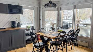 Una cocina moderna con comedor, ventanas amplias y vistas al exterior.