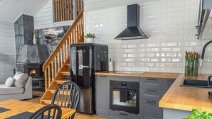Una cocina moderna con una isla central, horno integrado y campana extractora negra.