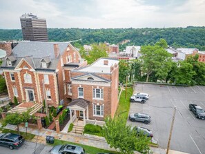 A large brick building with a prominent entrance and a parking lot in front.