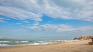 Ein Strand mit klarem Himmel und Wellen.