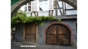 Un bâtiment doté d’une porte en bois et d’une entrée en arc de cercle.