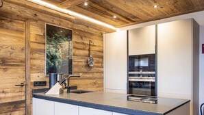 Una cocina moderna con paneles de madera, una isla grande con pileta y electrodomésticos integrados.