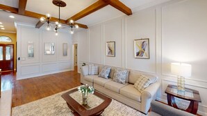 A spacious living room with a wooden ceiling, a beige sofa, a coffee table, and a chandelier. - 4 Bedroom3 Bath,Pool table, Pool, Crib (Plano)