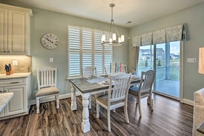 A dining area with a wooden table, white chairs, and a clock on the wall. - 4BR Fam Villa Near Bethany Beach w/ Pool Sleeps 10 (Millville)