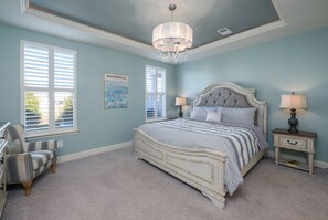 A bedroom with a bed, two bedside tables, a chair, and a chandelier. - 4BR Fam Villa Near Bethany Beach w/ Pool Sleeps 10 (Millville)