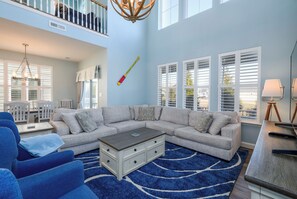 A living room with a sectional sofa, a coffee table, and a blue rug.