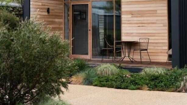 A modern wooden cabin with large glass windows, a patio with outdoor seating, and a well-maintained garden. - Riverstone - Perfectly positioned on the Ovens River and providing a one-of-a-kind experience (Porepunkah)