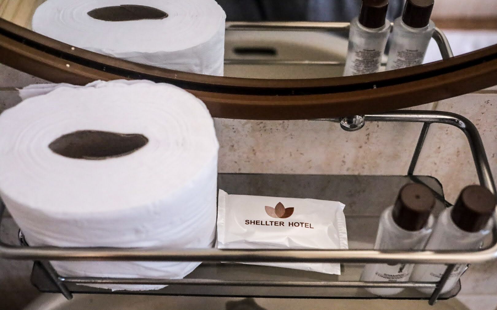 Een hotelbadkamer met toiletpapierrollen, een handdoek en toiletartikelen.