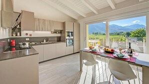 A modern kitchen with a large window overlooking a mountainous landscape. - Mirabelle - Apartment With Terrace & Views (Dro)