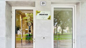 A hotel entrance with a glass door, a clock, and a sign for 'Dream Hub'. - Hotel Dream Hub (Mestre)