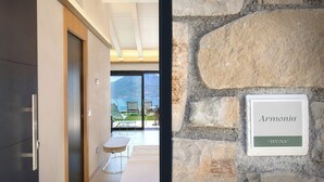 En modern hotellinteriör med en vägg av sten och en skylt med texten ”Armonia La Divina 2”.