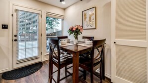 A dining area with a table set for four, a ceiling fan, and a door with a window. - Updated 4 Bedroom Home Pool, Sleeps 8 Wifi Garage (Carrollton)