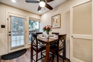 A dining area with a table set for four, a ceiling fan, and a door with a window. - Updated 4 Bedroom Home Pool, Sleeps 8 Wifi Garage (Carrollton)