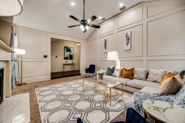 A modern living room with a sofa, coffee table, and a ceiling fan.