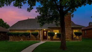 A two-story house with a brick exterior, a front door, and a chimney. - Updated 4 Bedroom Home Pool, Sleeps 8 Wifi Garage (Carrollton)