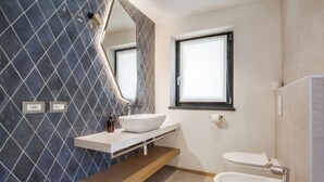 A modern bathroom with a large mirror, a white sink, a bathtub, and a window. - Villa Divina22-APT Unica-With pool and lake view (Veneto)