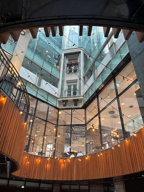A modern atrium with a glass ceiling, wooden slats, and string lights. - LE SEOUL HOTEL (Seoul)