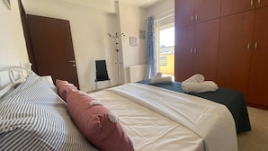 Et hotelværelse med to senge, et skab, en stol og en radiator.