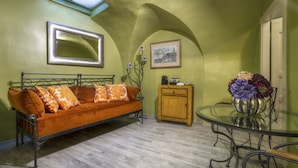 A room with a sofa, a glass table, a cabinet, and a framed picture on the wall. - Black Star Suites (Prague)