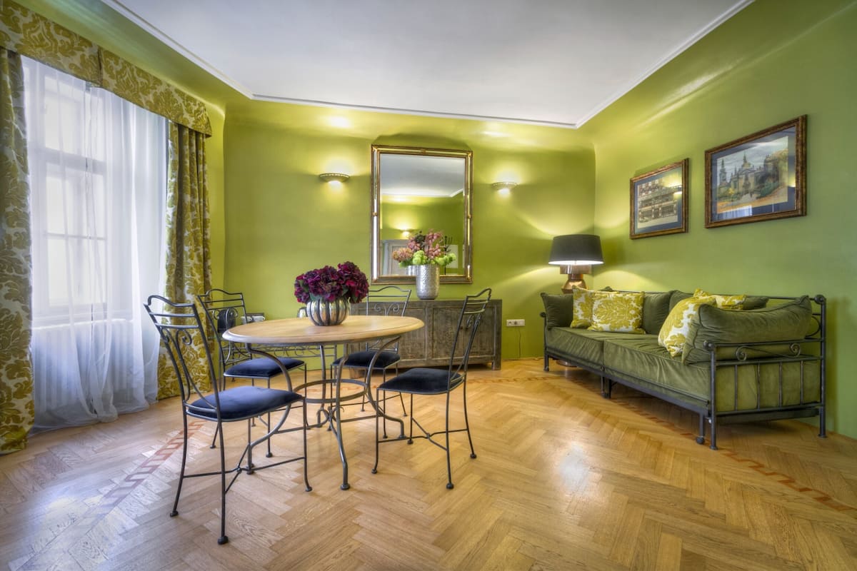 A dining area with a round table, chairs, and a vase of flowers.