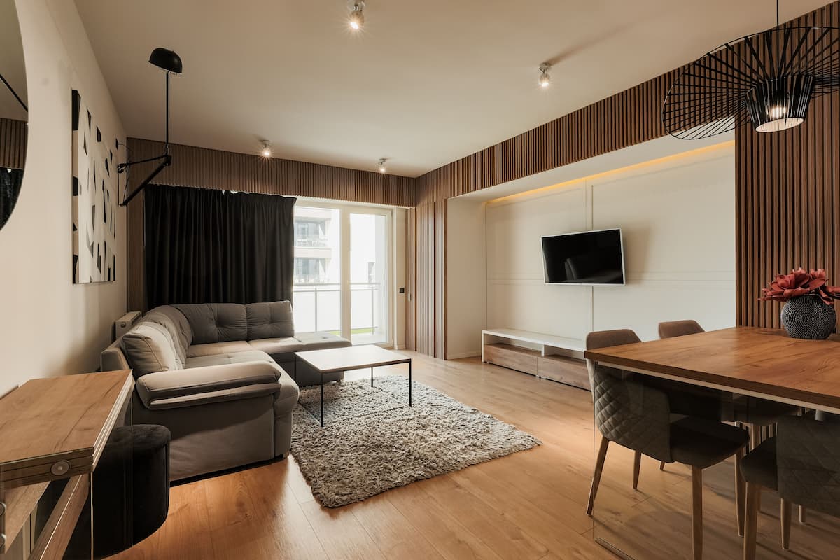 A modern living room with a sofa, coffee table, and dining area.