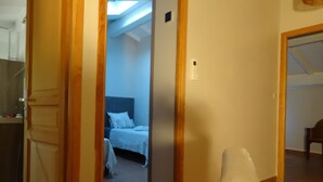 Een hotelkamer met een bed, nachtkastje en raam.
