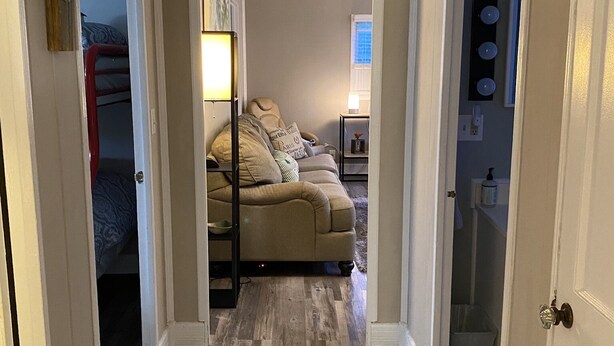 A hallway leading to a living room with a sofa, a lamp, and a rug. - Awesome Unbeatable 5-Star Location…walk to ND in 10 minutes! (South Bend)