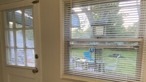 A room with a door and two windows with blinds. A wicker basket with apples and oranges is on a table. - Awesome Unbeatable 5-Star Location…walk to ND in 10 minutes! (South Bend)