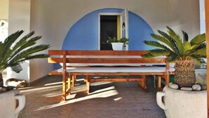 A wooden bench under a blue archway with potted plants on either side. - Holiday apartment With sea view and terrace (Komarna)