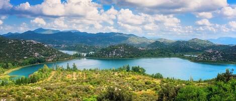 A lake surrounded by mountains and greenery.