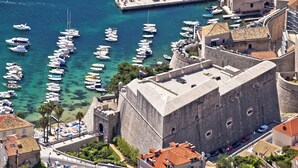 A historic coastal town with a fortified building, a marina with numerous boats, and a clear blue sea. - Holiday apartment With sea view and terrace (Komarna)