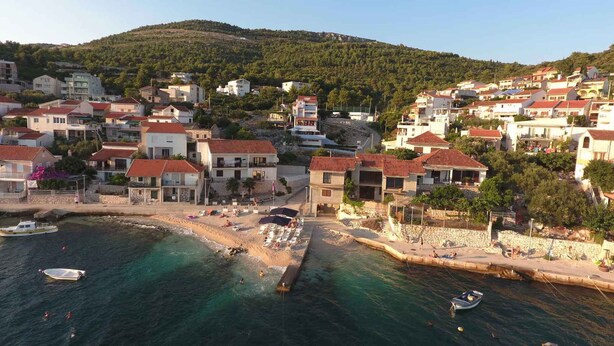 A coastal town with buildings, a beach, and boats. - Holiday apartment With sea view and terrace (Komarna)