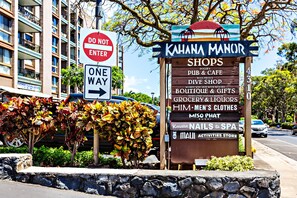 Segnale per Kahana Manor che elenca negozi tra cui un pub, un negozio di ristorazione, una boutique e altro ancora.